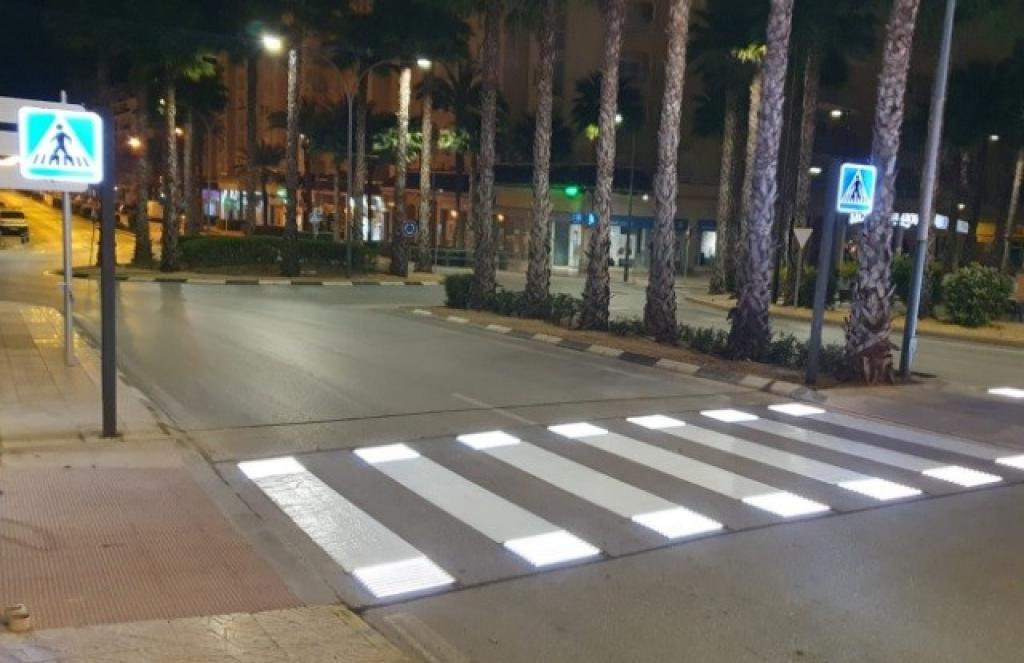 Night shot of pedestrians crossing road full of mopeds in busy